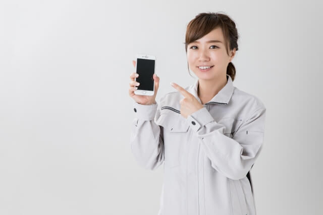 スマホを指さす女性